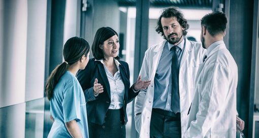 Businesswoman talking with doctors in hospital